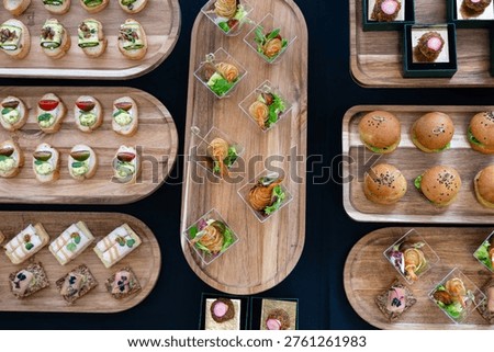 Overhead view of assorted bite-size desserts and berry parfaits on a catering buffet tray