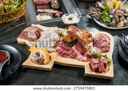 An overhead view of assorted raw meats arranged on a wooden board ready for grilling. The variety showcases premium cuts suitable for barbecue restaurants and grill menu promotion.