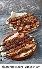 Overhead View Of Assortment Of Shashlik And Kebabs Over Grey Background