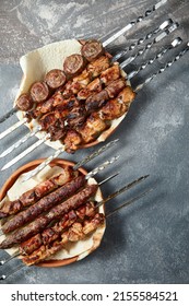 Overhead View Of Assortment Of Shashlik And Kebabs Over Grey Background