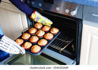 Overhead View Of A Baking Tray With Freshly Prepared Plain Chocolate Vanilla Muffins Holding By A Child