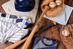 Overhead View Of Baseball Gear On A Rustic Wood Surface. Items Include, Home Plate, Helmet, Baseball, Ball, Glove, Catchers Mitt, Score Book, Pants, Belt And Bats.