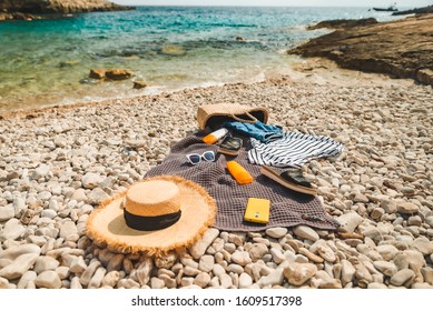 Overhead View Of Beach Stuff Blanket With Sun Protection Cream Straw Hat With Bag