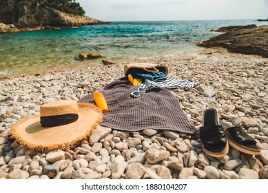 Overhead View Of Beach Stuff Blanket With Sun Protection Cream Straw Hat With Bag