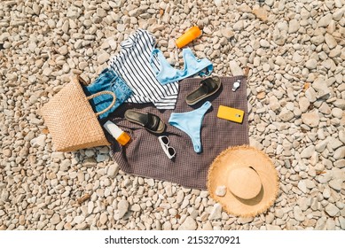 Overhead View Of Beach Stuff Blanket With Sun Protection Cream Straw Hat With Bag Flat Lay