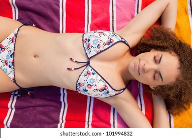 Overhead View Of A Beautiful And Relaxed Woman Napping On Her Orange Beach Towel