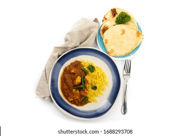 Overhead View Of A Blue Plate Of Indian Buttered Chicken And Curry Rice With A Plate Of Naan Bread On A White Background