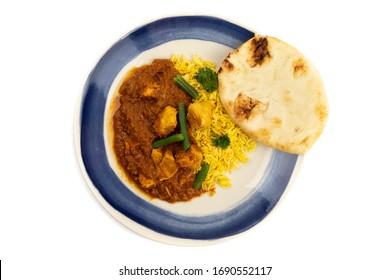 Overhead View Of A Blue Plate Of Indian Buttered Chicken With Green Beans And Curry Rice And Naan Bread Isolated On A White Background