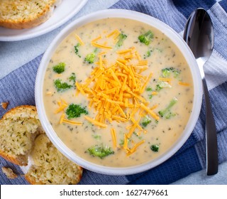 Overhead View Of A Bowl Of Creamy Broccoli Cheddar Cheese Soup With Toasted Cheese Bread