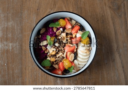 Overhead view of a bowl filled with fruit salad and granola