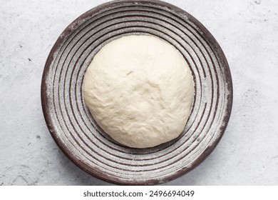 Overhead view of bread dough rising in banneton basket , top view of proofing dough in a wood proofing basket, process of making artisan bread - Powered by Shutterstock