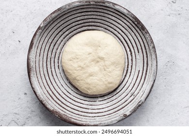 Overhead view of bread dough rising in banneton basket , top view of proofing dough in a wood proofing basket, process of making artisan bread - Powered by Shutterstock