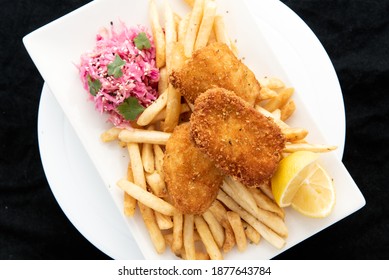 Overhead View Of Breaded Halibut Fish And Chips Served With French Fries And Lemon Garnishment For A Plate Of Delicious Finger Food.