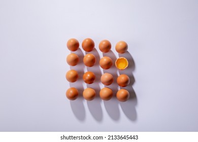 Overhead View Of Brown Eggs With One Broken Egg Arranged In Square On Table. Unaltered, Healthy Food, Raw Food, Organic, Protein, Fresh, Egg Yolk, Shadow And Still Life.