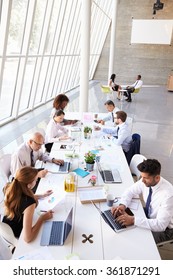 Overhead View Of Business Meeting Around Boardroom Table