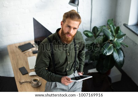 overhead view of businessman holding tablet and looking at camera Stock photo © 