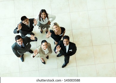 overhead view of businesspeople looking up and waving