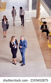 Overhead View Of Businesspeople Meeting In Lobby Of Busy Modern Office Building