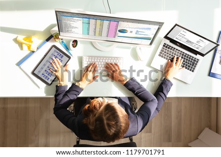 Overhead View Of A Businesswoman Doing Multitasking Work On Electronic Devices