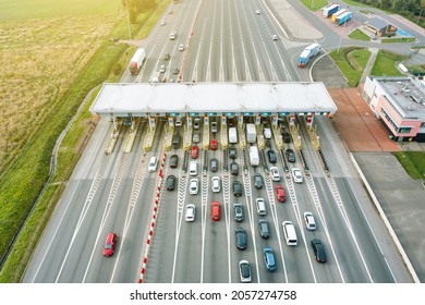 An overhead view of a busy toll road with many cars queuing up to pay the highway toll - Shutterstock ID 2057274758