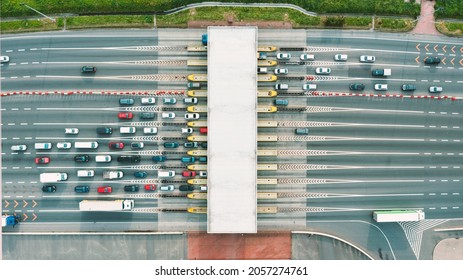 An overhead view of a busy toll road with many cars queuing up to pay the highway toll - Shutterstock ID 2057274761