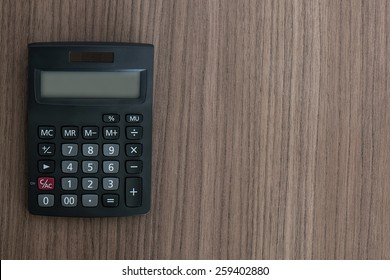 Overhead View Of A Calculator On A Wood Desk