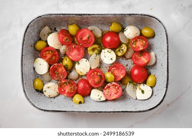 Overhead view of caprese salad with cherry tomatoes, olives, pickled onion and mozzarella - Powered by Shutterstock