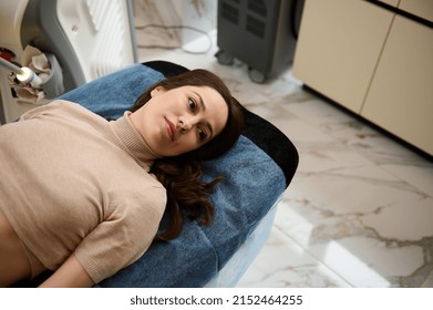 Overhead view of a Caucasian middle aged woman lying on a daybed getting ready for beauty and body care treatment in medical spa clinic