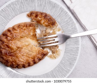 Overhead View Of A Chicken Pot Pie On A Plate With Fork And Napkin.