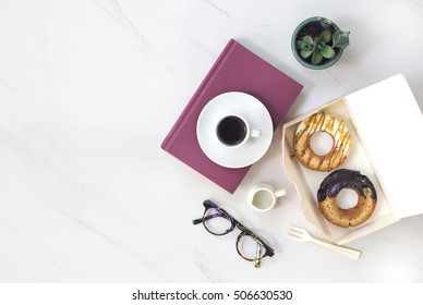 Overhead View Of Chocolate Cake Donuts With Salted Caramel Glaze With A Cup Of Espresso On Marble Table Top. Afternoon Me Time Book Reading With Dessert And Coffee. Text Space Images.