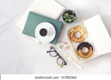 Overhead View Of Chocolate Cake Donuts With Salted Caramel Glaze With A Cup Of Espresso On Marble Table Top. Afternoon Me Time Book Reading With Dessert And Coffee. Text Space Images.