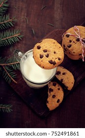 Overhead View Of Chocolate Chip Cookies And Milk On Dark Wooden Background