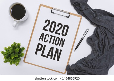 Overhead View Of Clipboard On White Desk. 2020 Action Plan.