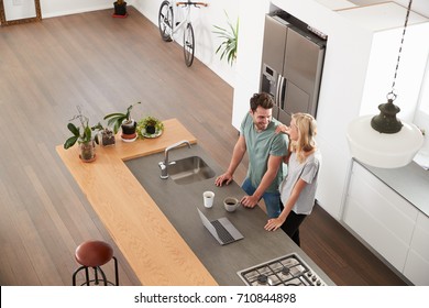 Overhead View Of Couple Looking At Laptop In Modern Kitchen - Powered by Shutterstock