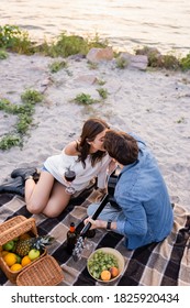 Overhead View Couple With Wine And Acoustic Guitar Kissing On Beach At Evening