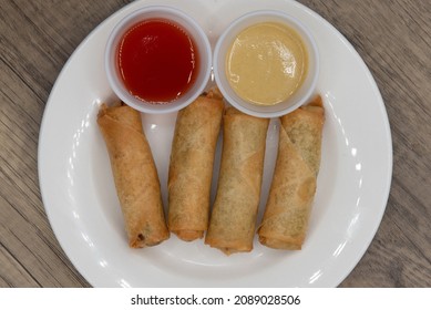 Overhead View Of Crispy Egg Rolls With Two Choices Of Dipping Sauce As An Appetizer Before The Meal.