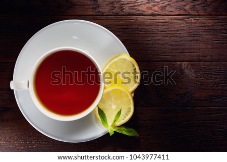 Overhead view of a cup of tea with cinnamom, mint leaves and fruits of star anise. Close-up photo.
