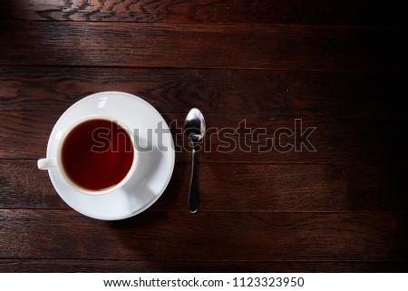 Overhead view of a cup of tea with cinnamom, mint leaves and fruits of star anise. Close-up photo.