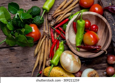 Overhead view of a delicious assortment of farm fresh vegetables, herbs and mushrooms spread out on a rustic wooden table - Shutterstock ID 309211259