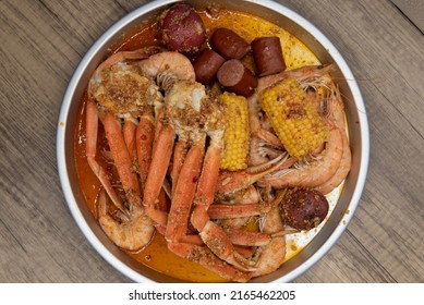 Overhead View Of Delicious Buttery Plate Of Boiled Snow Crab Legs With Corn On The Cob And Sausage For A Tasty Seafood Meal.