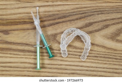 Overhead View Of Dental Whitening Trays And Gel Tubes On Aged Wood