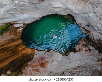 Overhead View Of Dimosari Waterfall Lake With Happy Man Floating On The Back Lefkada Island Greece