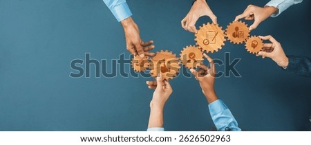 Overhead view of diverse hands interacting with wooden gears that symbolize various business concepts, highlighting teamwork and collaborative efforts in a professional environment. Amity