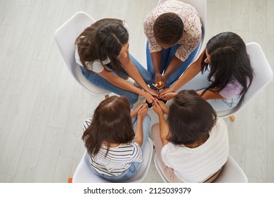 Overhead View Of A Diverse Team Of Women Sitting In A Circle. View From Above Of A Multiethnic Group Of Young Ladies Sitting In A Circle And Talking. Concept Of Support Within Female Community