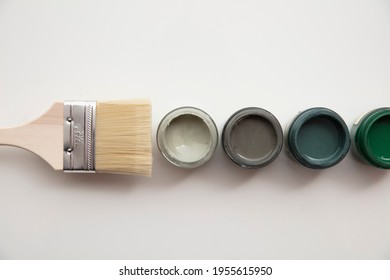 Overhead View Of A DIY Paint Brush With Trendy Green Sample Paint Pots