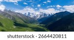 Overhead View of Dramatic Snow Capped Mountain Range Valley Green Meadow and Blue Sky