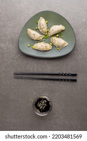 Overhead View Of Dumplings, Soy Sauce And Chopsticks On Grey Background. Asian Tasty Home Cooked Food And Healthy Eating.