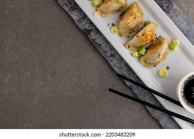 Overhead View Of Dumplings, Soy Sauce And Chopsticks On Grey Background. Asian Tasty Home Cooked Food And Healthy Eating.