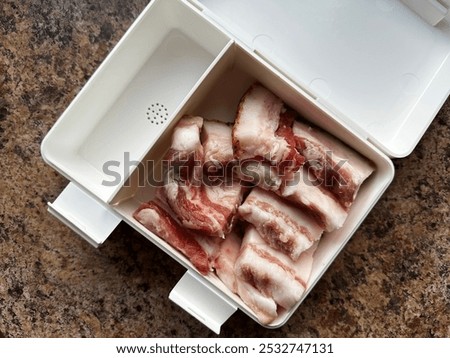 Overhead View Of Fat Bacon In Plastic Box For Snack On Brown Marble Background