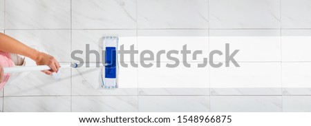 An Overhead View Of A Female Cleaning The White Floor With Wet Mop Imagine de stoc © 